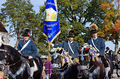 Beflaggte Reiter beim Colomansfest mit Colomansritt in Schwangau im Allgäu